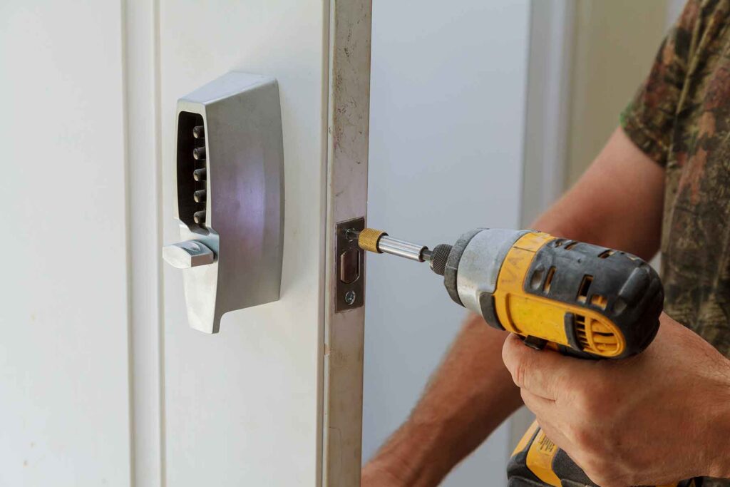 A locksmith installing a lock in a commercial door